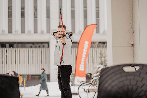 Étudiant qui fait du tir à l'arc dans espace enneigé