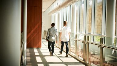 Deux étudiants et une étudiante qui marchent dans un corridor