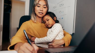 Mère qui étudie avec son enfant dans les bras