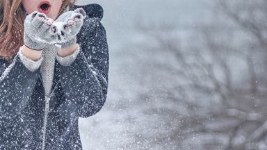 Jeune fille qui souffle de la neige